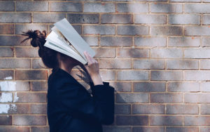 Una donna con un libro sul viso